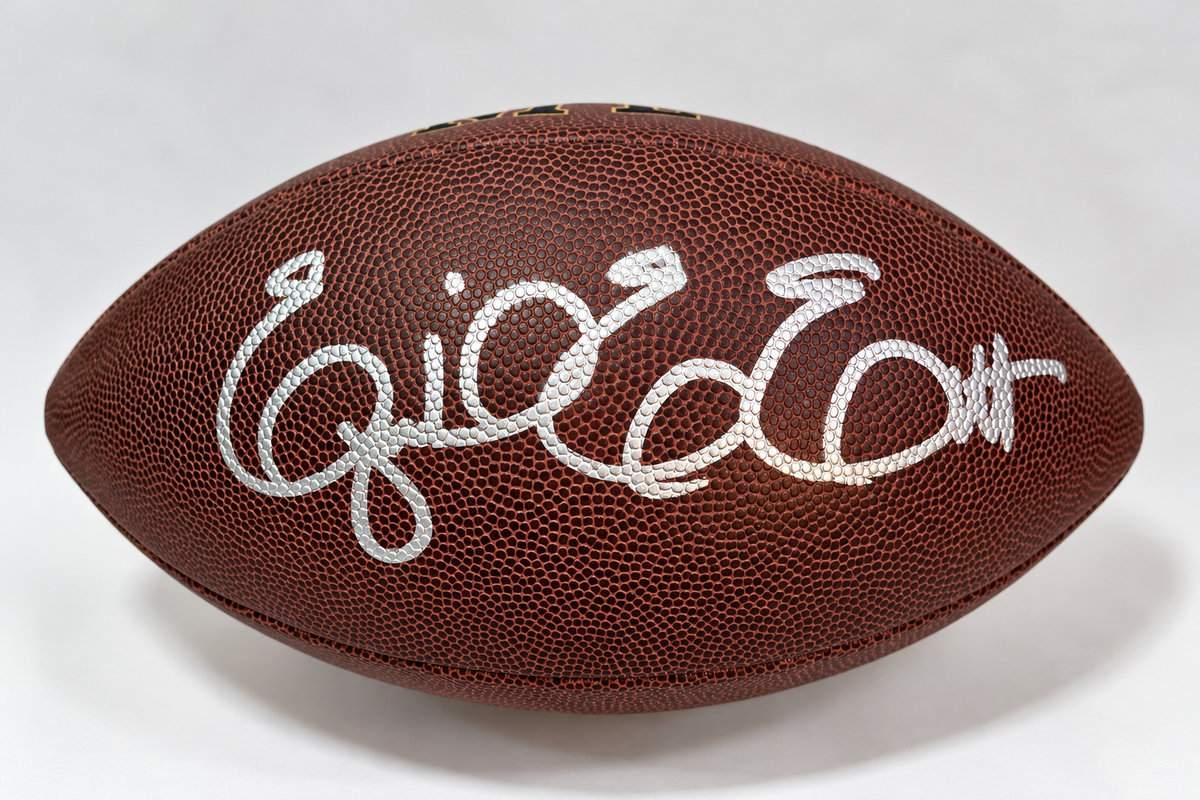Ezekiel Elliott autographed Wilson NFL football with silver-colored signature on textured brown leather