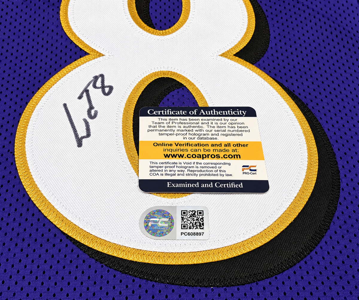 Close-up of Lamar Jackson signature on purple number 8 jersey with PRO-Cert COA card and hologram PC608897
